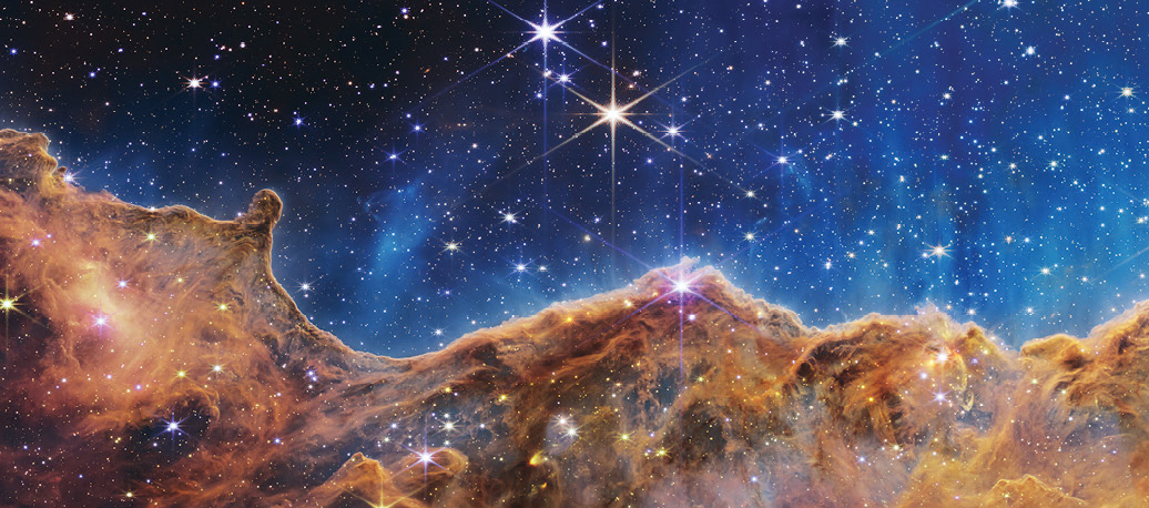 Cosmic cliffs in the Carina Nebula as seen through the James Webb space telescope.
