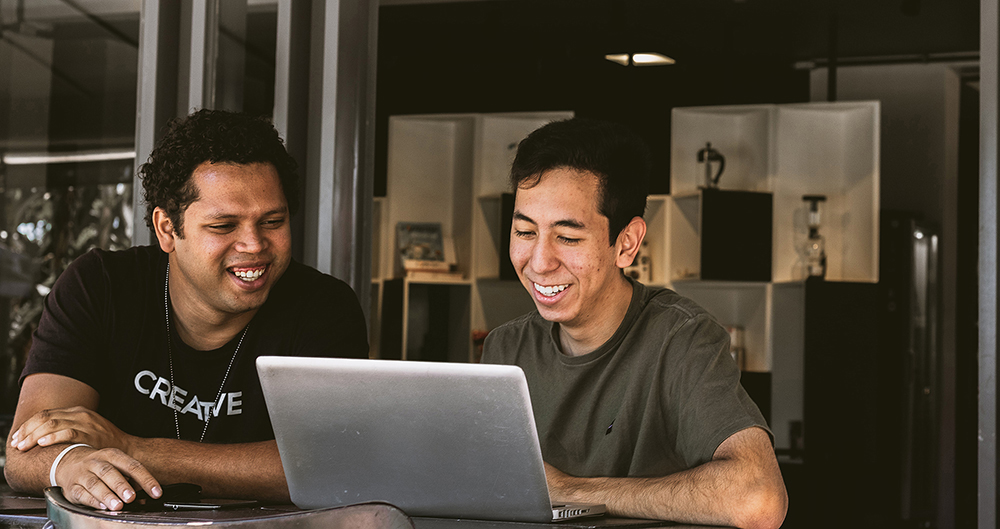 Deux professionnels à un bureau font de la recherche sur un ordinateur.