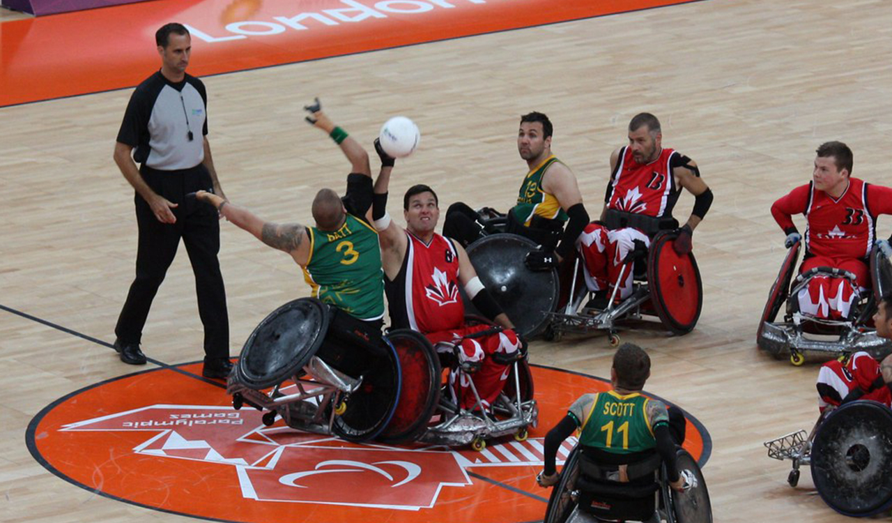 Une photographie d'olympiens canadiens qui jouent au rugby en fauteuil roulant lors des Olympiques de Londres de 2012.