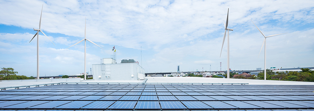 Panneaux solaires sur le toit d'une usine avec éolienne.