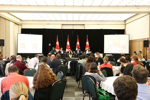 Wide-angle photo showing five private sector panelists speaking at the ISED Managers' Forum event