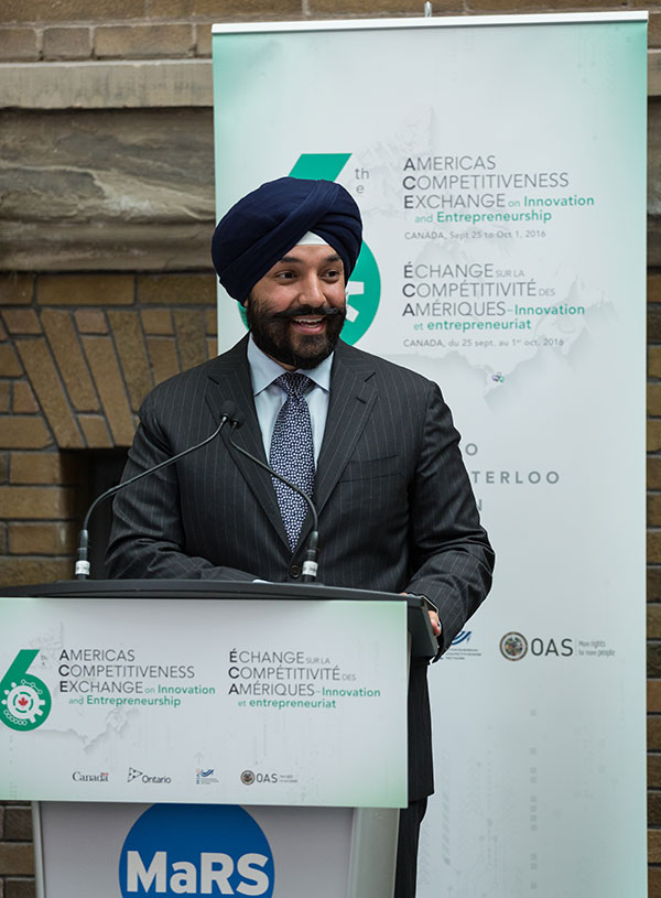 Photo of Minister Bains speaking at a podium during the Americas Competitiveness Exchange event