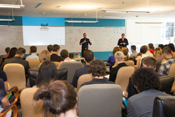 Wide-angle photo showing the co-founders of Blockchain Canada speaking to ISED employees about disruptive technologies