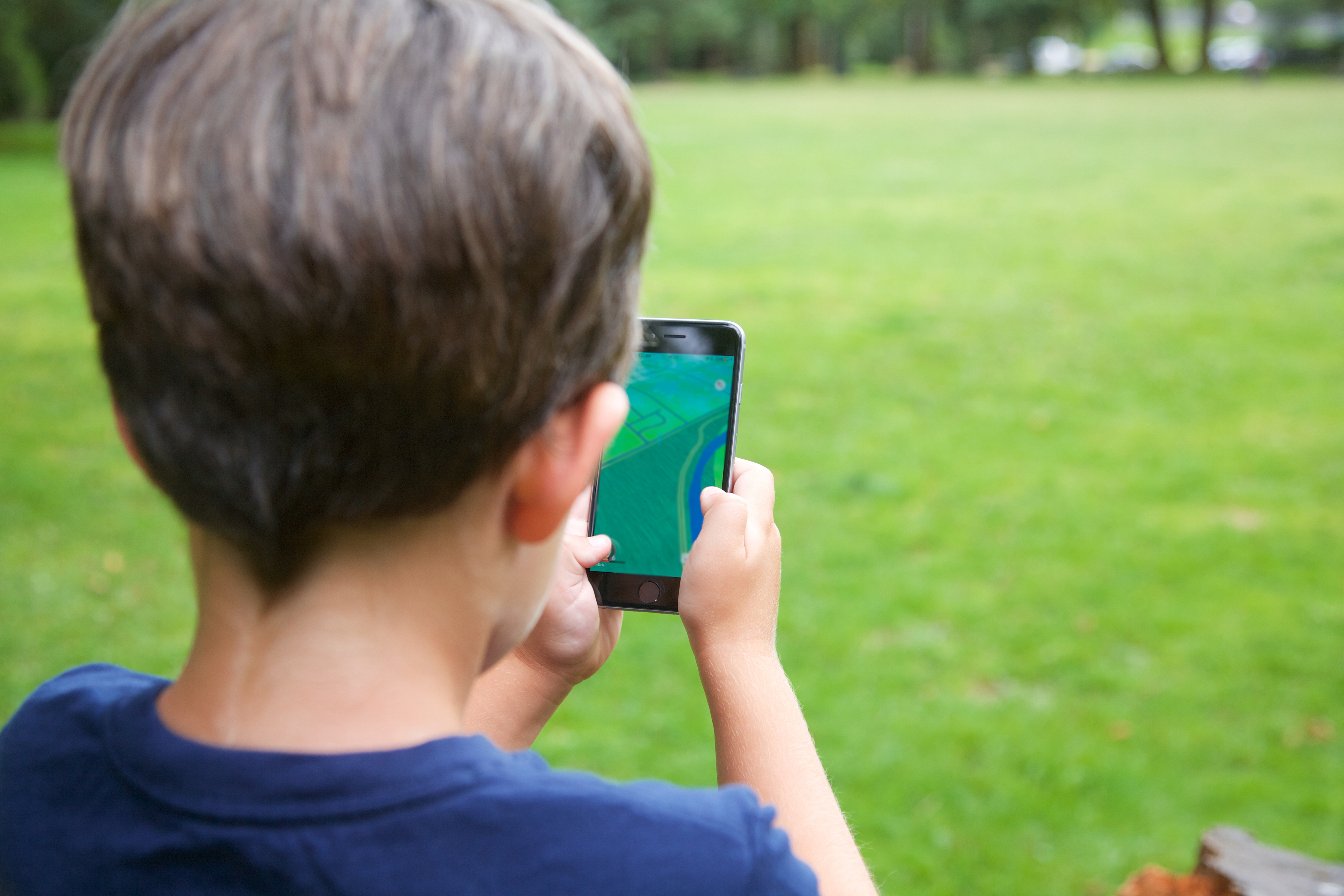 Boy outside, using a mobile device