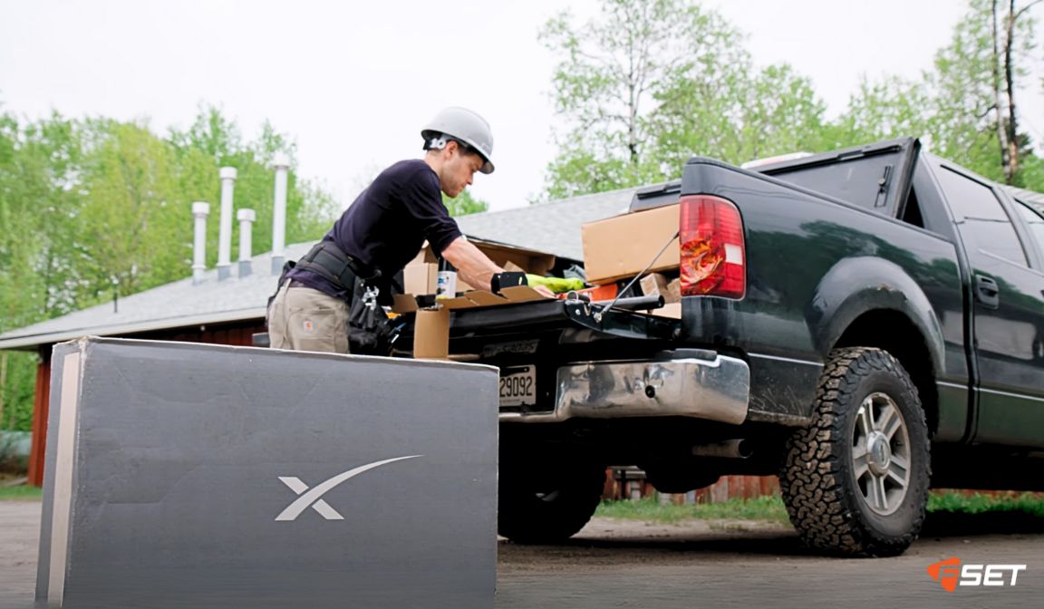 Homme retirant des boîtes et du matériel d'un camion